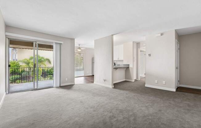 A spacious living room with a sliding glass door leading to a backyard.