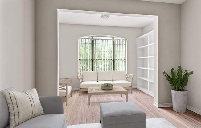 A living room with a grey couch, a wooden coffee table, and a potted plant.