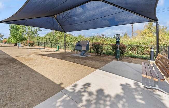 a picnic area with benches and a blue canopy