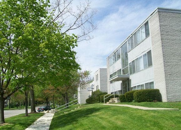 Charlton Apartments exterior with sidewalk and trees