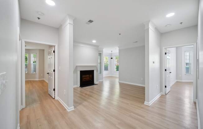 a renovated living room with a fireplace and wooden floors