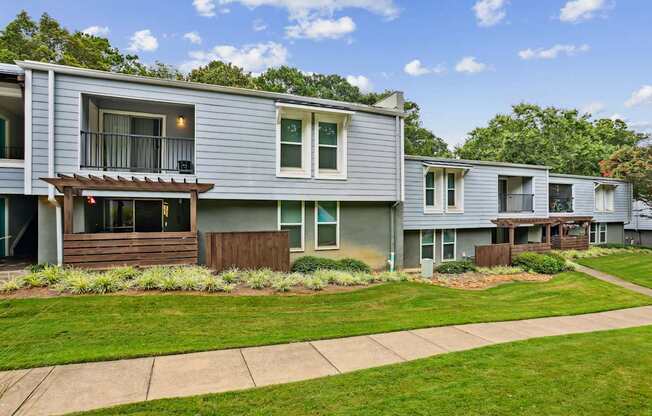 A row of houses with green lawns in front.
