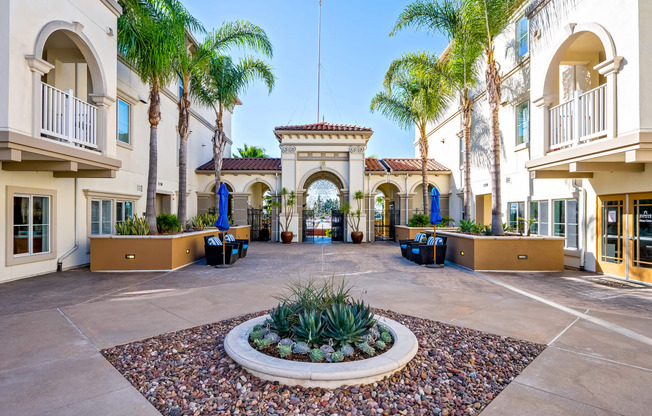 a courtyard with a fountain and palm trees at the preserve at great pond apartments in windsor