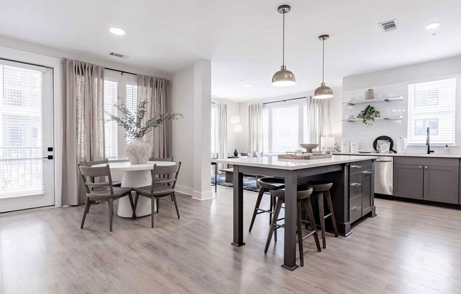 Bright kitchen area with dark wood accents and white countertops at Novel Cary