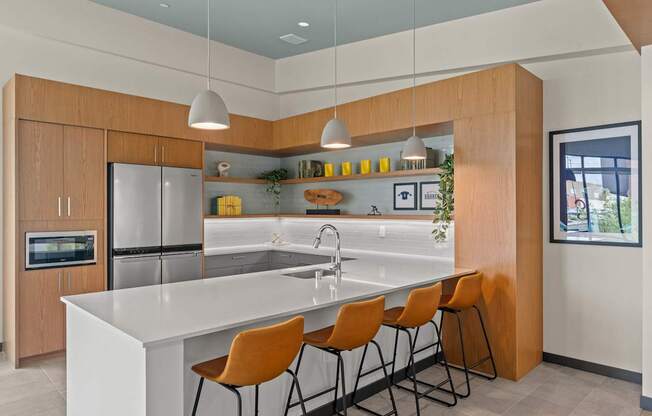 A modern kitchen with a white countertop and orange chairs.
