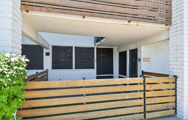 A wooden fence in front of a house with a glass door.