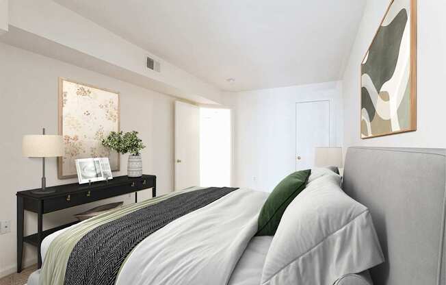 A bedroom with a bed, nightstand, and a painting on the wall.