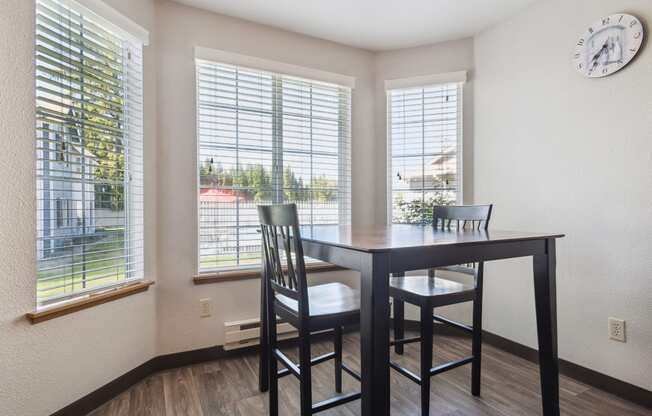 a dining room with a table and chairs and windows