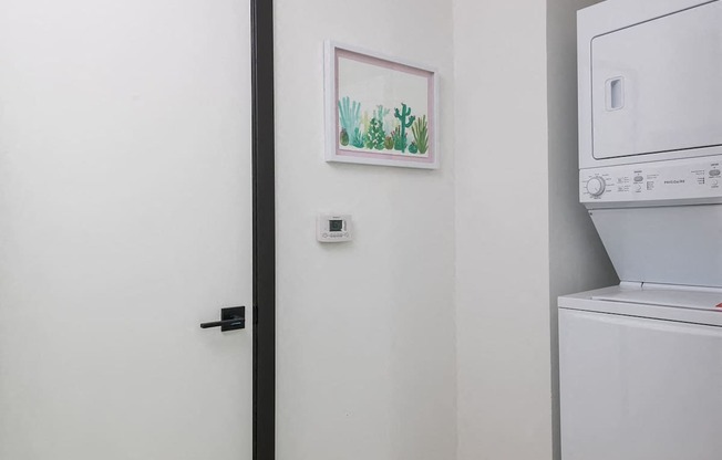 A white washing machine sits next to a white door.