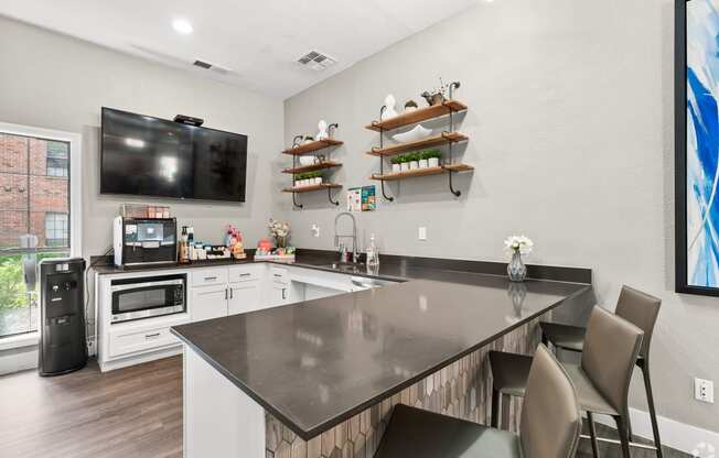 a kitchen with a large center island with a breakfast bar and a flat screen tv on the