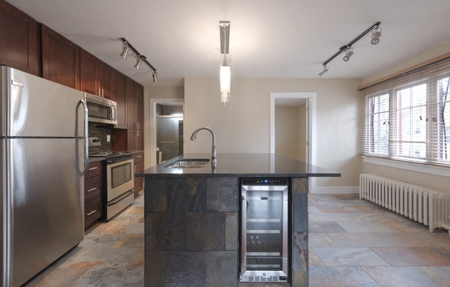 a kitchen with stainless steel appliances and a marble counter top