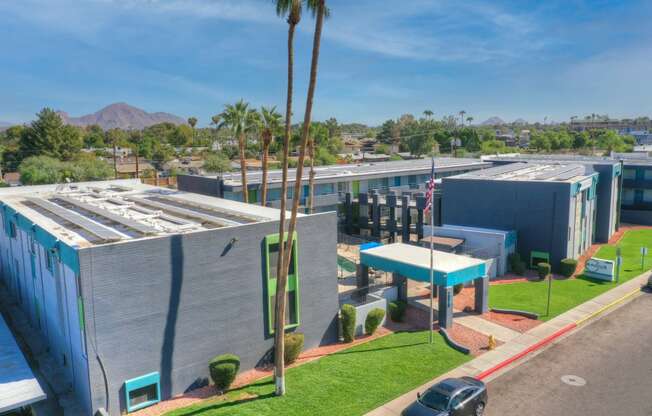 an aerial view of a building with palm trees and a parking lot