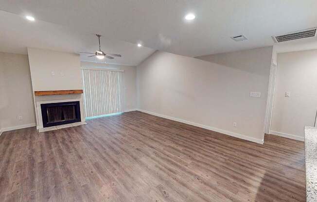 A room with a fireplace and wooden flooring.