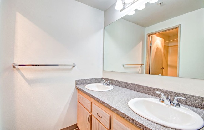 the ensuite bathroom has dual sinks and a large mirror