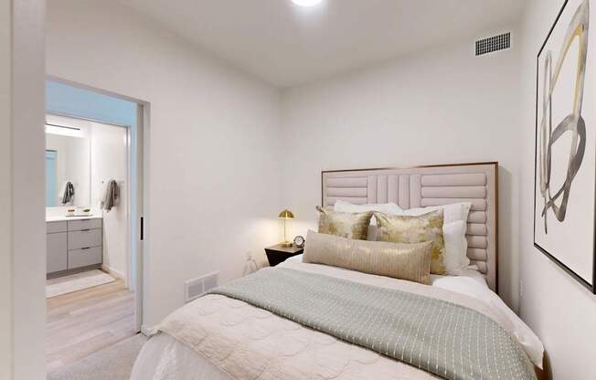 A bedroom with a bed, nightstand, and a painting on the wall.