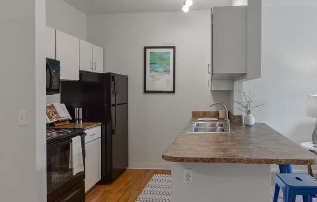 a kitchen with a counter top and a black refrigerator