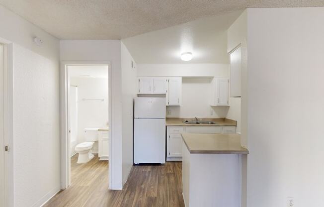 an empty kitchen with a white refrigerator and sink at La Terraza, Phoenix, 85018