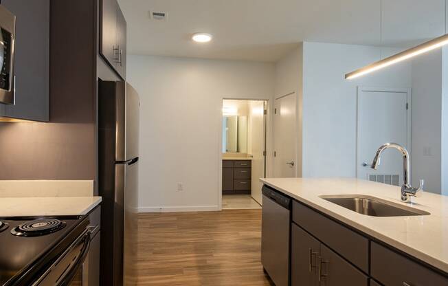 a kitchen with an island and a sink and a refrigerator
