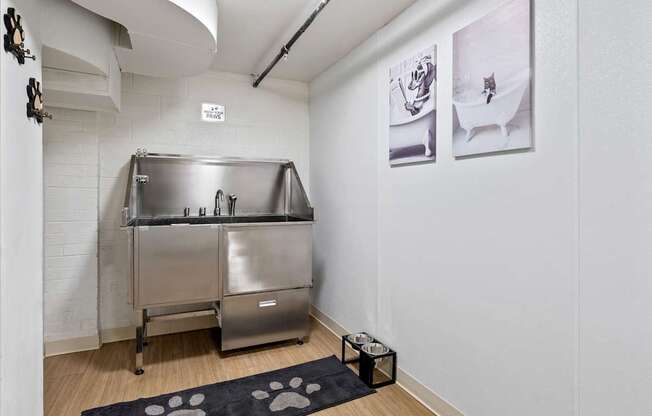 A stainless steel kitchen appliance in a white room with a black and white rug.