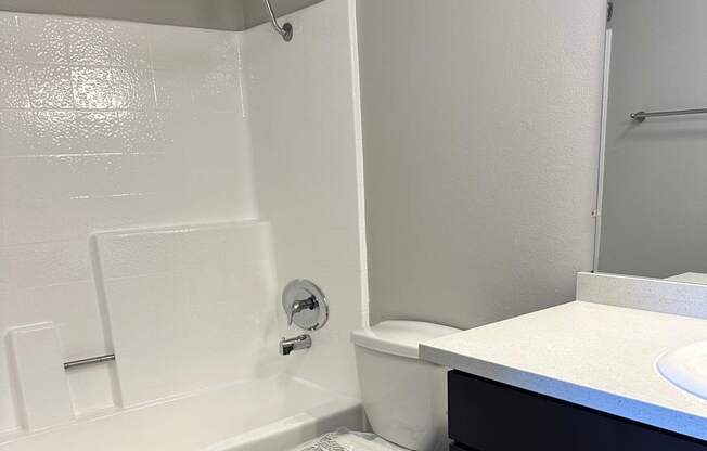 A white toilet with a white lid and a white toilet paper holder.