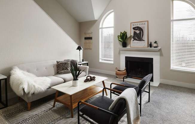 a living room with a white couch and two black chairs