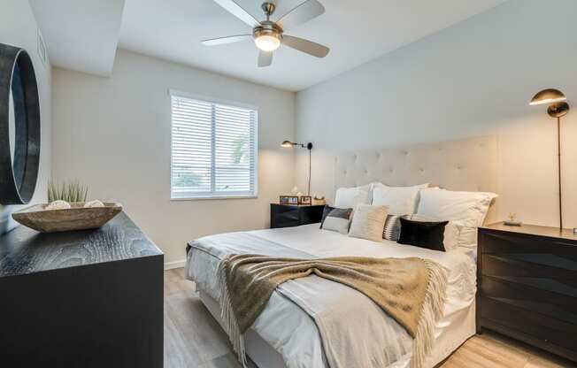 a bedroom with a bed and a ceiling fan