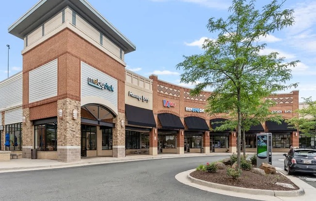 a store front of a brick building with a parking lot