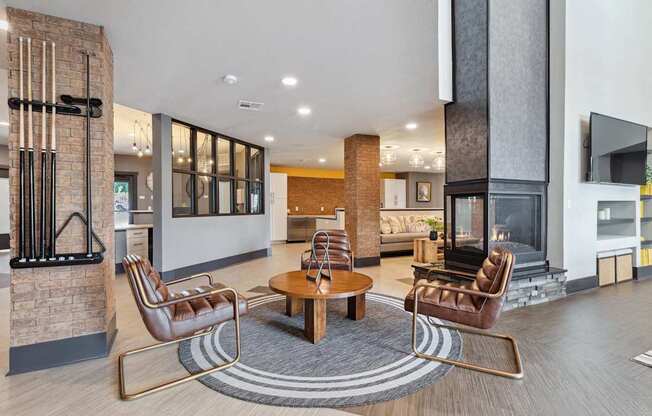 A modern living room with a fireplace and leather chairs.
