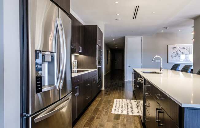 a modern kitchen with stainless steel appliances and wooden floors
