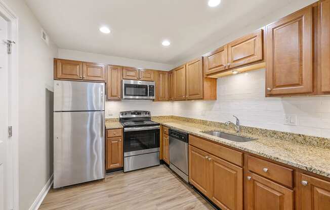 a kitchen with wooden cabinets and stainless steel appliances