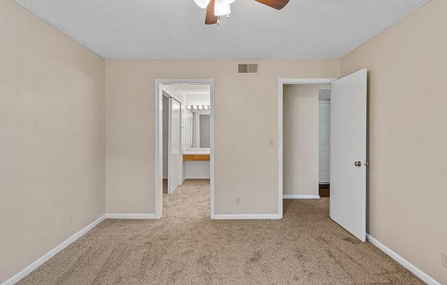 an empty room with pink lights on the wall and a ceiling fan