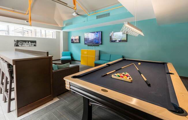a games room with a pool table and a tv