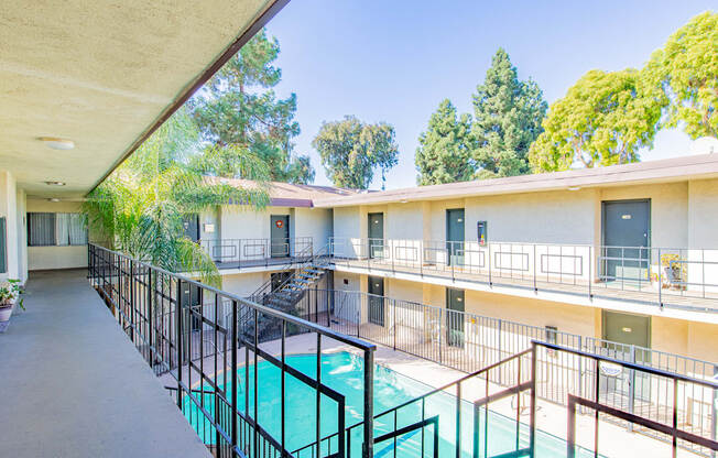 a balcony with a pool and a building with trees