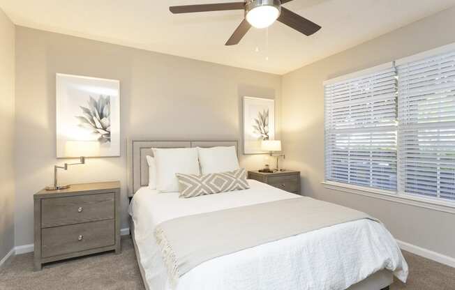 a bedroom with a bed and a ceiling fan