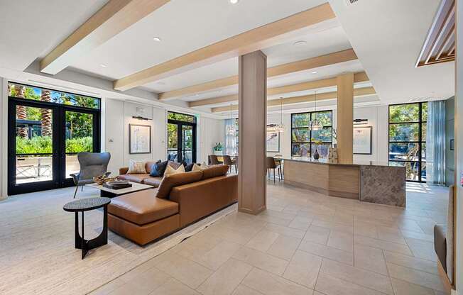 Stylish clubroom lounge with designer seating, wood accents, and walls of windows for gathering and relaxing