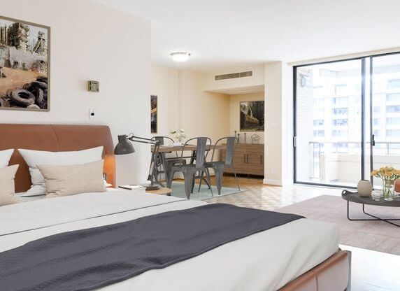 A bedroom with a large bed and a balcony.