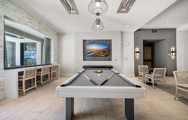 Game lounge featuring a billiards table, bar seating, and TVs for lively nights with friends