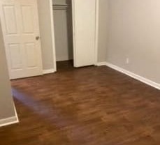 a living room with a wooden floor and a white door