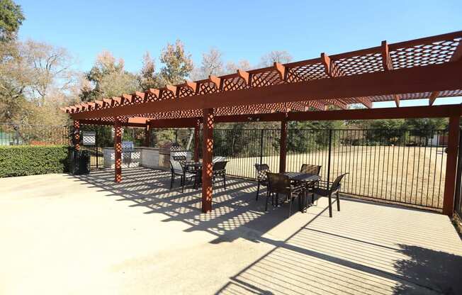 View of grilling station in fenced pool area with counters to prep food and seating