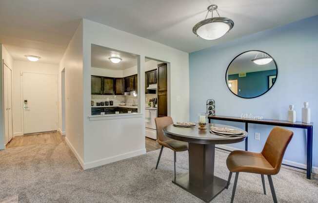Apartment in Southfield with a dining area with a table and chairs and a kitchen in the background