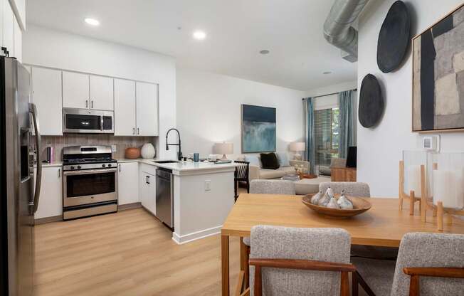 A modern kitchen with a wooden table and grey chairs.
