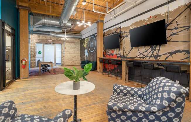 a room with two blue and white chairs and a table with a potted plant