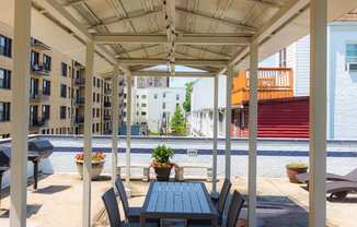 a patio with a wooden table and chairs and a pool