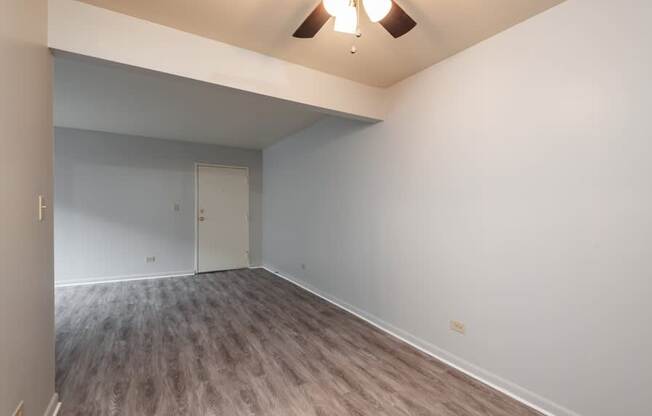 A room with a white door and a brown floor.