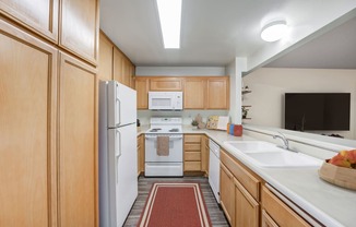 a kitchen with white appliances and wooden cabinets