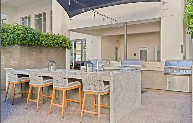 A patio with a table and chairs and a grill.