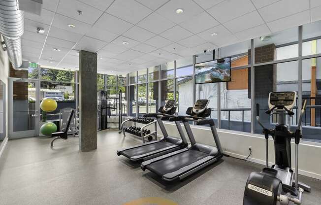 a gym with treadmills and other exercise equipment  at Sedona Apartments, Seattle