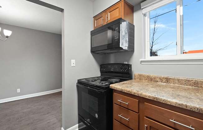 an empty kitchen with a stove and a microwave