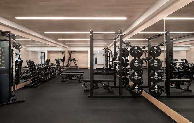 a gym with a lot of weights and cardio equipment at The Paxton, Brooklyn, 11201