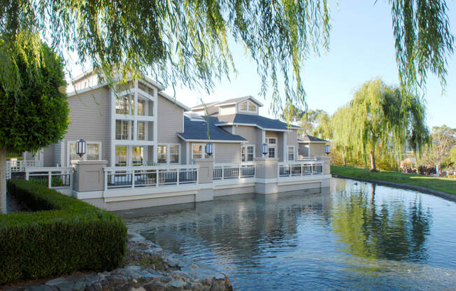 a large house sitting on the water next to a lake